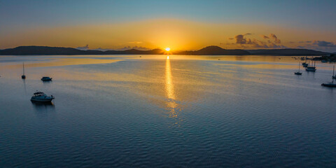 Aerial sunrise waterscape over the bay with boats