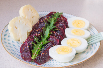 Breakfast, dinner, lunch is prepared from boiled beets, arugula, broccoli and boiled eggs