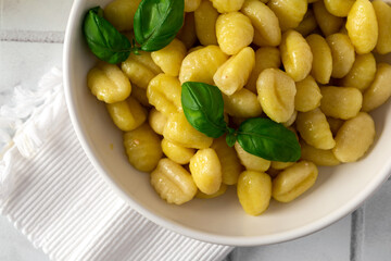 Italian gnocchi with basil on a white kitchen table