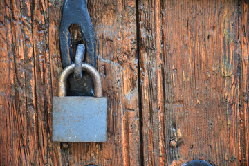 Old rusty lock hook and padlock on wooden door. Old rustic wooden door with padlock vintage concept