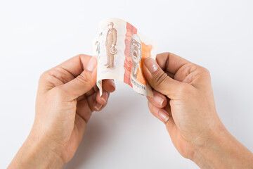 a person folds a twenty thousand Colombian peso bill.