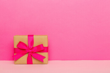 holiday paper present tied pink ribbon bow top view with copy space. Flat lay holiday background. Birthday or christmas present. Christmas gift box concept with copy space
