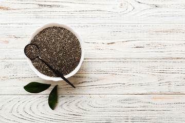 Chia seeds in bowl and spoon on colored background. Healthy Salvia hispanica in small bowl. Healthy superfood