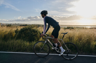 Man riding on a gravel bike on the road at sunset.Empty city road.
Sports motivation.Murcia region in Spain