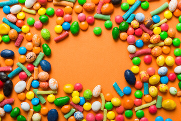 Fototapeta na wymiar Mixed collection of colorful candy, on colored background. Flat lay, top view. frame of colorful chocolate coated candy