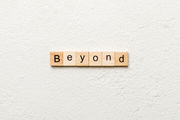 BEYOND word written on wood block. BEYOND text on cement table for your desing, concept