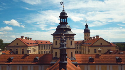 Obraz premium Metal gilded weather vane in the form of a family coat of arms on a high spire above a medieval castle in Europe. Symbolism of the Radzivils family.