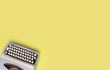 Overhead top view of a vintage aqua blue typewriter against a yellow background