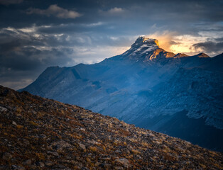 Light and storm clouds on mountain peak