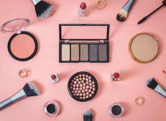 A set of female cosmetics on a pink background.