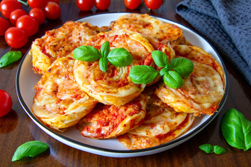 Puff pastry snacks with tomatoes sauce and cheese