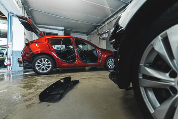 Red car body at repair shop, indoor background shot. High quality photo