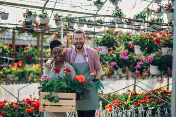 Multiracial florists working in a green house plant nursery - Powered by Adobe