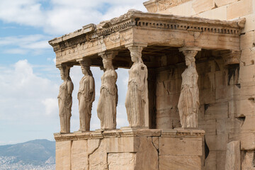 The Caryatids of Erechtheion Temple (Erechtheum) at the archaeological site of Acropolis. Caryatids are sculpted female figures used as decorative architectural support, close up angled view