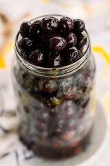 Various olives flavored with spices in white cup and glass jar. Green olives, black olives. Front and top shot on a white background	
