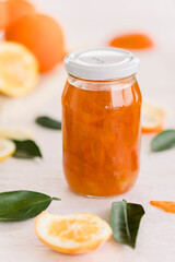 Fresh bitter orange marmalade with ripe fruit offered as closeup on a rustic black board with copy space
