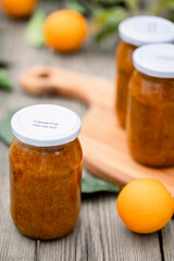 tasty tangerine jam in glass jar on wooden table.ball of tangerine jam