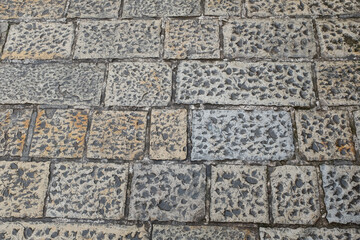 Cobblestone tiles street with big stones, top view. Ancient stone floor texture. Old pavement for a poster, calendar, post, screensaver, wallpaper, postcard, cover, website. High quality photo