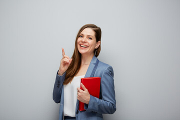 Woman teacher or smiling student girl pointing finger up isolated portrait..