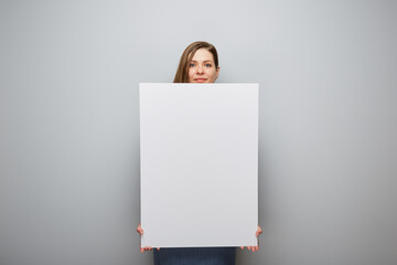 Smiling woman holding white board with empty copy space.