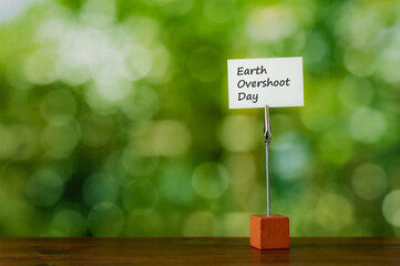 There is a piece of paper with the word Earth Overshoot Day. It is eye-catching image.