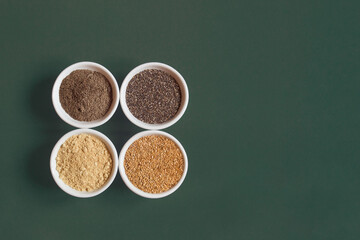 Chia and flax seeds both ground and whole on white ceramic bowls on a colorful studio background with copy space. Healthy Seeds to Eat.