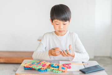 アルファベットのおもちゃで英語・英単語を覚える小学生低学年の男の子（知育）
