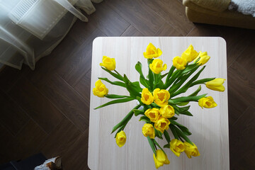 Bouquet of yellow tulips in a vase, rural interior
