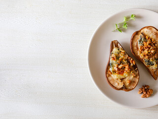 Homemade baked pears with blue cheese, nuts and honey on a plate. French cuisine. Keto diet. Vegetarian lunch. Top view