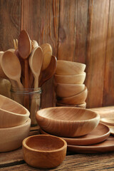 Many different wooden dishware and utensils on table