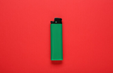 Stylish small pocket lighter on red background, top view