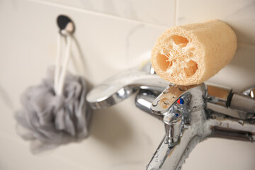 Grey shower puff and loofah sponge in bathroom, closeup
