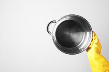 Woman holding empty pot on white background, closeup. Space for text