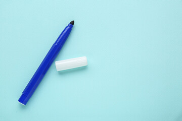 Colorful marker on light blue background, flat lay. Space for text