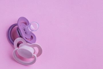 New baby pacifiers on pink background, flat lay. Space for text