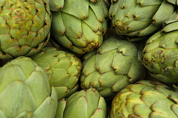 Many fresh raw artichokes as background, top view