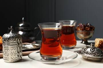 Glasses of tea and vintage tea set on white wooden table