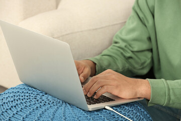 African American man typing on laptop indoors, closeup