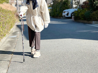 住宅地を杖をついて歩く足元_前から