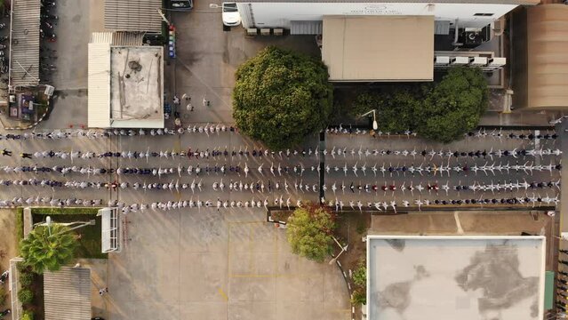 Lot of People factory worker stretching exercise in Factory at Morning before working aerial top view. Worker warm up for readiness of the body. Team workout healthy lifestyle