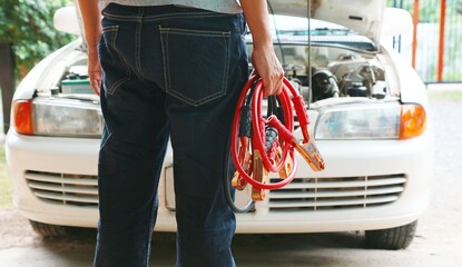 Man Connecting Battery Cable Copper Wire For Repairing Jumpers And Electrical Maintenance Of Engines Car problems that won't start.