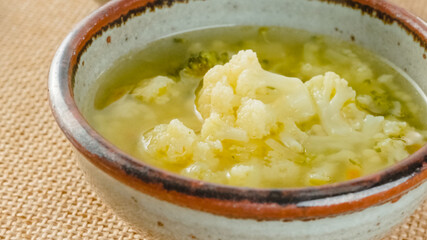 Cauliflower broccoli soup in a bowl close-up on a table