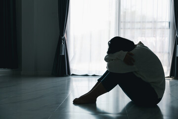 Concept of sad teenage girl depression. Upset teenage girl sitting at floor indoors. Anxiety young...