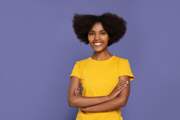 Portrait of smiling African American woman on purple background. Space for text