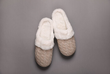 Pair of beautiful soft slippers on grey background, top view