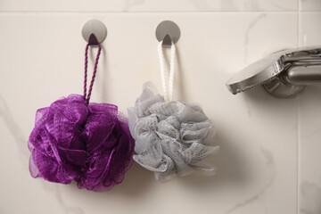 Shower puffs hanging near faucet in bathroom