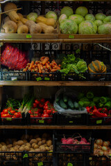 Street market. Vertical vegetable counter. Concept of buying farm food. Fresh raw vegetables, fruits, berries. Pumpkin, cabbage, carrot, potato, tomato, pepper. Shop window, cucumber, onion, radish