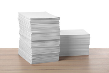 Stacks of paper sheets on wooden table against white background