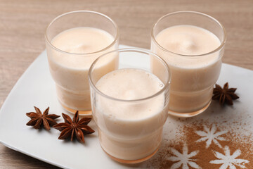 Delicious eggnog with anise on wooden table