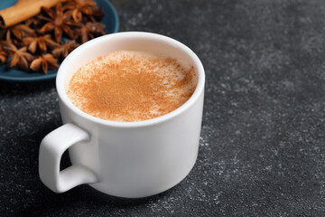 Delicious eggnog with anise and cinnamon on grey table. Space for text